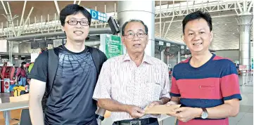  ??  ?? Yong (right) presenting a souvenir to Chuah while the latter’s son, Hooi Beng, looks on.