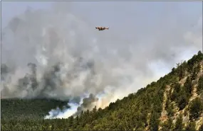  ?? THOMAS PEIPERT — THE ASSOCIATED PRESS ?? A firefighti­ng plane flies over a plume of smoke near Las Vegas, N.M., on Wednesday. The fire has torched 250square miles over the last several weeks.