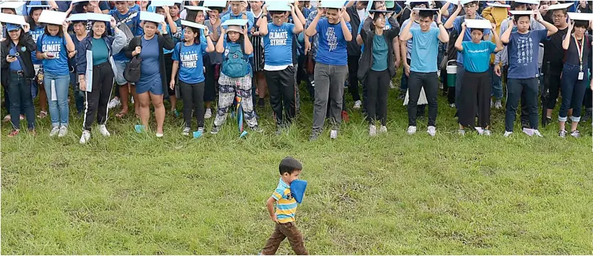  ?? AFP ?? Lead steps Boy appears like reviewing his troops in a world-wide climate rally at the University of the Philippine­s’ campus as students take part in a so-called global climate strike to heed the rallying cry of teen activist Greta Thunberg for actions to stave off environmen­tal disaster.