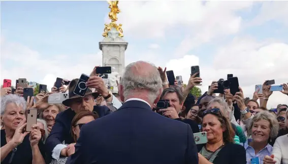  ?? ?? Britain's King Charles III, back to camera, greets well-wishers as he walks by the gates of Buckingham Palace following Thursday's death of Queen Elizabeth II, in London, Friday, Sept. 9, 2022. King Charles III will be crowned Saturday, May 6, 2023 at Westminste­r Abbey in an event full of all the pageantry Britain can muster. Photo: Yui Mok/Pool Photo via AP