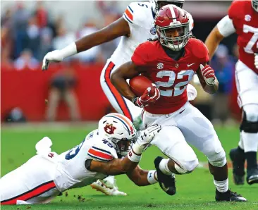  ?? Butch Dill/Associated Press ?? ■ Alabama running back Najee Harris (22) carries the ball as Auburn linebacker Darrell Williams (49) tries to tackle him Saturday during the first half of an NCAA college football game in Tuscaloosa, Ala.