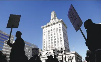  ?? Justin Sullivan / Getty Images ?? Oakland city workers, shown picketing Tuesday outside City Hall, began striking this week over pay. The city wants the union to agree to state mediation to resolve the labor dispute.