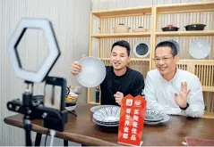  ??  ?? Le 24 avril 2020, Huang Wenjie, chef du district de Dehua, fait la promotion en direct des produits locaux en céramique.