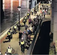  ??  ?? (Right) People hurry down Borough High Street as police deal with the incident on Saturday night; (left) people are led to safety away from London Bridge after the attack; (below left) armed police in St Thomas Street on Sunday morning, near to the...