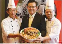  ??  ?? Dragon-i chief executive officer Datuk Henry Yip (centre) with (from left) master chef Lee Soon Fatt and executive chef Tai Chi Kong presenting the Dragon-i Signature Prosperity Abalone Treasure Pot.