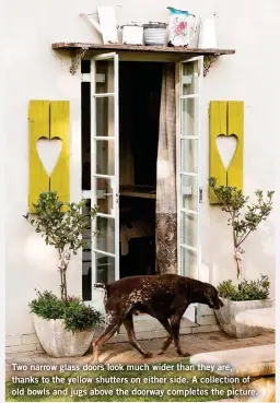  ??  ?? Two narrow glass doors look much wider than they are, thanks to the yellow shutters on either side. A collection of old bowls and jugs above the doorway completes the picture.