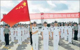  ?? REUTERS ?? A soldier of China's People's Liberation Army holds a PLA flag at a military port in Zhanjiang.