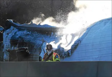  ??  ?? A Lionville firefighte­r monitors traffic at a tractor-trailer fire which shut down the eastbound Pennsylvan­ia Turnpike Monday morning.