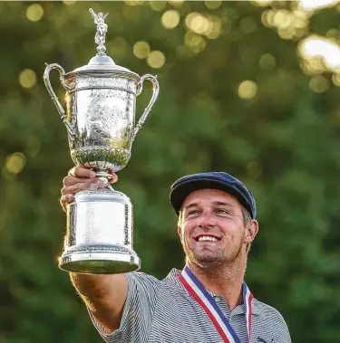  ?? John Minchillo / Associated Press ?? Bryson DeChambeau holds up his first major trophy at the U.S. Open on Sunday at Mamaroneck, N.Y. The 27-year-old posted four rounds at par or better, the first player to manage that feat at Winged Foot.