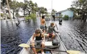  ?? JOE BURBANK / ORLANDO SENTINEL VIA AP ?? Geneva, Fla., residents navigate flooded streets Tuesday after Lake Harney in Seminole County crested 8 feet above sea level with historic flooding from Hurricane Ian.