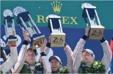  ?? — AFP ?? (L to R) Brendon Hartley, Earl Bamber and Timo Bernhard celebrate with their trophies on the podium in Le Mans, western France.