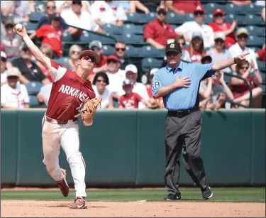  ?? Craven Whitlow/Special to News-Times ?? Long throw: Arkansas third baseman Casey Martin completes the put-out against Texas A&M deep down the line Saturday afternoon at Baum Stadium in Fayettevil­le. Martin scored one run with one put-out and four assists. The Hogs beat the Aggies 3-1 and are...