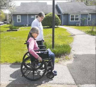  ??  ?? Brooks Quarry resident Debbie Moros, in front, navigates the walkway at the complex with Tenant Commission­er Jo-Ann Gargiulo on May 2. Brooks Quarry is in need of various upgrades, including new walkways.