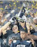  ??  ?? UCF coaches and players celebrate after winning the AAC Championsh­ip Game Saturday.