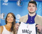  ?? ANDY JACOBSOHN/ASSOCIATED PRESS ?? Luka Doncic holds up a Mavericks jersey while his mother, Mirjam Poterbin, looks on in Dallas on Friday.