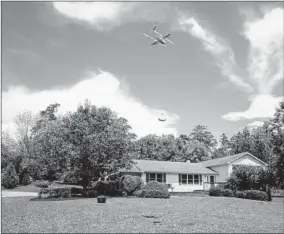  ?? CHARLES MOSTOLLER/BLOOMBERG ?? Alphabet Inc.’s Wing drone delivers a package in a demonstrat­ion of the technology Tuesday in Blacksburg, Va.