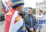  ??  ?? Far right activist Stephen Yaxley-lennon, who goes by the name Tommy Robinson, speaks to an antibrexit demonstrat­or, as a Trump supporter stands behind him, outside the Houses of Parliament in London on Tuesday. — Reuters