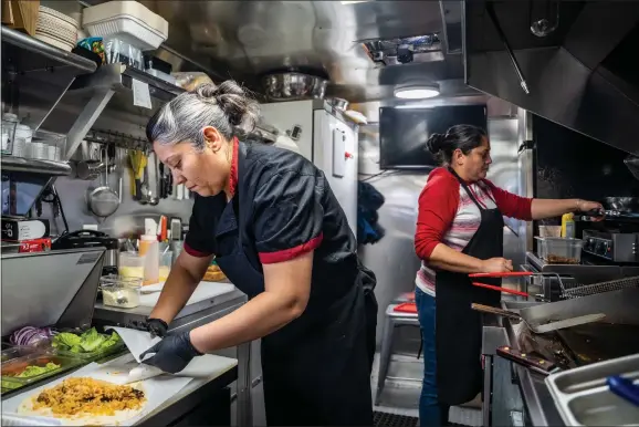 ?? NATHAN BURTON/Taos News ?? Alondra Galindo, chef and owner of La Carreta food truck, left, and sister Yolanda Prieto prepares customers orders Saturday (Jan. 7).