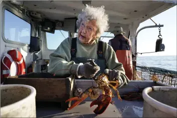  ?? PHOTOS BY ROBERT F. BUKATY — THE ASSOCIATED PRESS ?? Virginia Oliver, age 101, works as a sternman, measuring and banding lobsters on her son Max Oliver’s boat, Tuesday off Rockland, Maine.