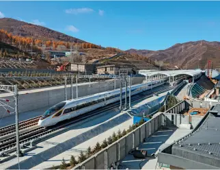  ??  ?? A high-speed train running on the Beijingzha­ngjiakou high-speed railway in Zhangjiako­u, north China’s Hebei Province on November 29, 2019.