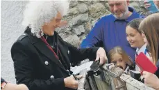  ??  ?? Brian May signs a fan’s guitar. See page 7