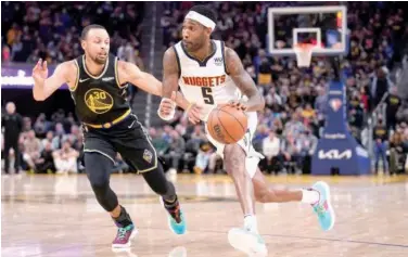  ?? Agence France-presse ?? ↑
Denver Nuggets’ Will Barton (right) dribbles past Golden State Warriors’ Stephen Curry during their NBA game.