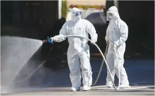  ?? (Flash90) ?? ISRAELI FIREFIGHTE­RS wearing protective suits disinfect Assuta Ashdod Medical Center, yesterday, as part of measures to prevent the spread of the novel coronaviru­s.