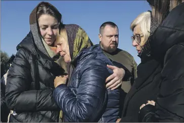  ?? Paula Bronstein Getty Images ?? FAMILY MEMBERS mourn Volodymyr Chovgun, 34, at his funeral Saturday in Zazymya, Ukraine. Citizens were warned of potential power outages and asked to conserve after Russian forces attacked an energy facility.