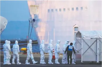  ?? KIM KyuNG-HOON/ REUTERS ?? Officers in protective gear enter the cruise ship Diamond Princess docked in Yokohama, south of Tokyo, Japan, on Feb. 7. The ship experience­d an outbreak of COVID-19 among its 2,666 passengers.