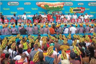  ??  ?? Women compete during Nathan's Famous Hotdog eating contest Tuesday in Brooklyn, New York.