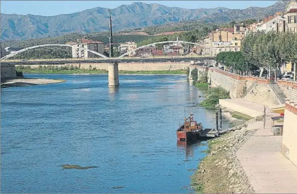  ?? VICENÇ LLURBA ?? El Ebro a su paso por Tortosa, con parte del lecho al descubiert­o; el poco caudal y el calor favorecen la acumulació­n de plantas acuáticas