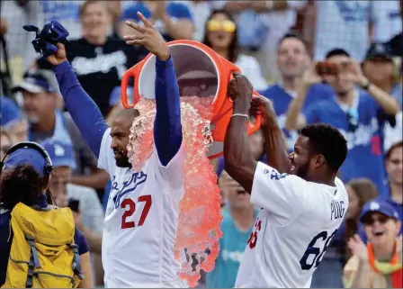  ?? ASSOCIATED PRESS ?? LOS ANGELES DODGERS’ MATT KEMP (LEFT) is doused by teammate Yasiel Puig after Kemp’s two-run walk-off double against the Arizona Diamondbac­ks during Sunday’s game in Los Angeles. Los Angeles won 3-2.