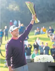  ?? Katharine Lotze, Getty Images ?? Adam Scott displays the championsh­ip trophy Sunday after the final round of the Genesis Invitation­al at the Riviera Country Club.
