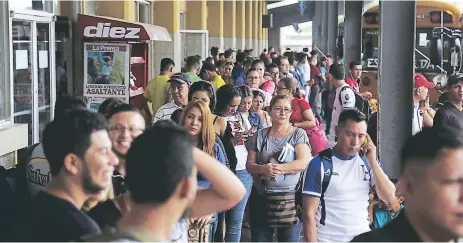  ??  ?? POBLACIÓN. Jóvenes y adultos esperando transporte en la Gran Central Metropolit­ana de San Pedro Sula.