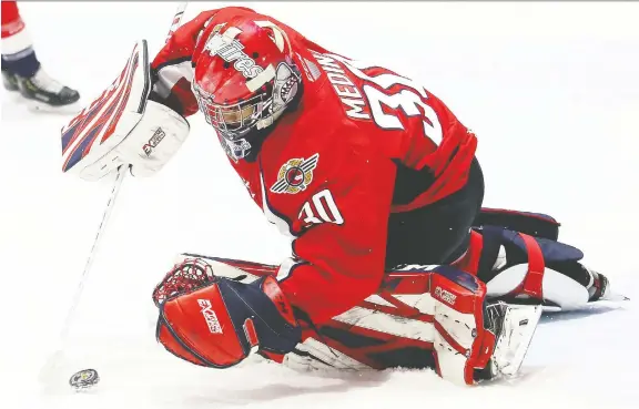  ?? PHOTOS: MARK MALONE ?? Spitfires goalie Xavier Medina covers the puck against the Sarnia Sting in the first period at Progressiv­e Auto Sales Arena in Sarnia Friday.