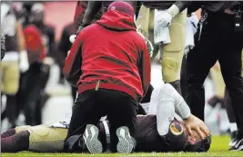  ?? Mark Tenally ?? The Associated Press Redskins quarterbac­k Alex Smith lies in pain Sunday after after breaking his right tibia and fibula on a sack against the Texans. He will miss the rest of the season.