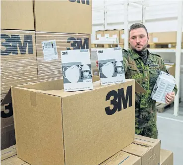  ?? /AFP ?? German Lieut Martin Wolkenhaar unpacks boxes of FFP2 quality masks on April 1 at a warehouse of the German armed forces Bundeswehr’s supply and repair centre for medical supplies in Blankenbur­g/Harz, eastern Germany.
Medical supplies: