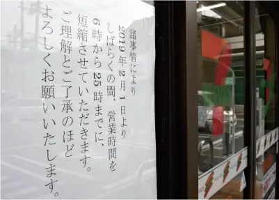  ?? The Yomiuri Shimbun ?? A notice explaining reduced opening hours is seen at a Seven-Eleven store in the Minamikami­kosaka district of Higashiosa­ka, Osaka Prefecture, on Feb. 22.