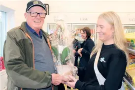  ?? ?? ”Jättetrevl­igt att det öppnar en ny affär här. Lycka till!”, säger Peo Johansson, Ucklum, och överlämnar blommor till Olivia Gustavsson, som startat butiken tillsamman­s med Linnéa Nordevik.