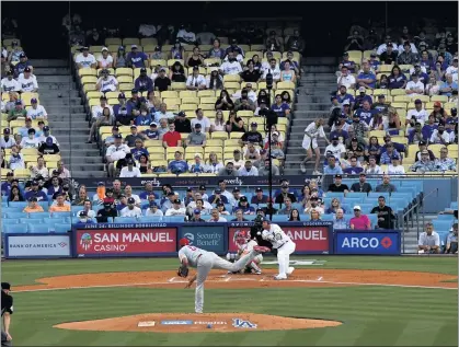  ?? KEITH BIRMINGHAM — STAFF PHOTOGRAPH­ER ?? Fans begin to fill seats in the first inning Tuesday for the Dodgers’ first game without attendance restrictio­ns this season as the Dodgers’ Justin Turner hits a single against the Philadelph­ia Phillies. Fans were still trickling in during the third inning, with about half wearing masks.