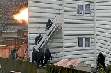  ?? PHOTO: ROSS GIBLIN/ STUFF ?? Armed offenders squad members enter the property near Hutt Hospital.