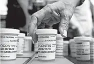  ?? JESSICA HILL/AP ?? Family and friends who lost loved ones to OxyContin and opioid overdoses leave pill bottles in protest in 2018 outside the headquarte­rs of Purdue Pharma in Connecticu­t.