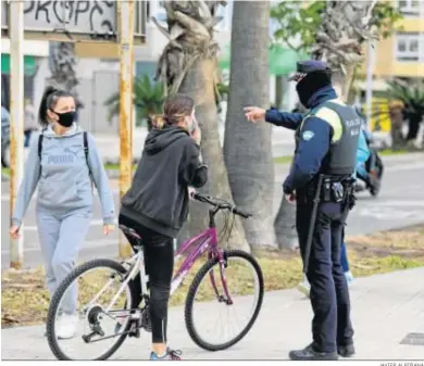  ?? JAVIER ALBIÑANA ?? Un policía local le hace una indicación a una mujer en bicicleta.