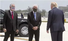  ?? PEDRO PORTAL pportal@miamiheral­d.com ?? From left, Miami-Dade County Commission­er Esteban Bovo and Dade Mayor Carlos Gimenez welcome President Donald Trump at Miami Internatio­nal Airport on Friday.