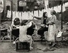  ??  ?? Walter Rosenblum’s “Group in Front of Fence, Pitt Street, Lower East Side, NY” is included in “A New York Minute: Street Photograph­y, 1920–1950” at the Cleveland Museum of Art.