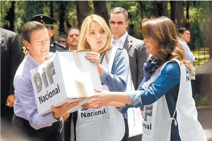  ??  ?? El Presidente y su esposa, Angélica Rivera, en el centro de acopio de víveres en Campo Marte.