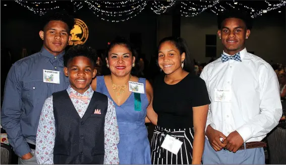  ?? NWA Democrat-Gazette/CARIN SCHOPPMEYE­R ?? Amelia Bautista (center), is joined by her children Bryndell Cook (from left), Bliyse Cook, Byanca Cook and Bryton Cook at the Single Parent Scholarshi­p Fund of Northwest Arkansas Spark of Hope on June 21 at the Fayettevil­le Town Center.