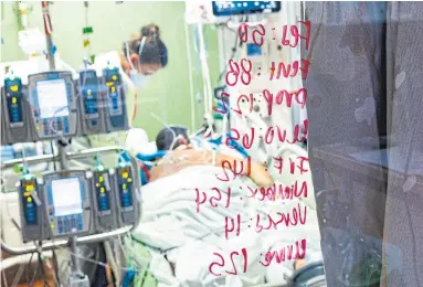  ?? KYLE GREEN THE ASSOCIATED PRESS ?? A registered nurse checks on a COVID-19 patient in an intensive care unit. COVID patients are often made to lie prone up to 14 or 16 hours at a time. Immobility can cause blood clots, despite anticoagul­ation therapy, writes Christine McColeman.