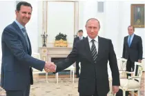  ??  ?? President Vladimir Putin ( R) shakes hands with his Syrian counterpar­t Bashar al- Assad ( L) during a meeting at the Kremlin in Moscow on October 21. Assad, on his first foreign visit since Syria’s war broke out, told his main backer and counterpar­t...