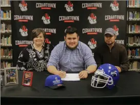  ?? Contribute­d photo by Gail Conner ?? Cruz Rodriguez is joined by his parents Stacey and Francisco Rodriguez for his official commitment to Shorter University during National Signing Day.